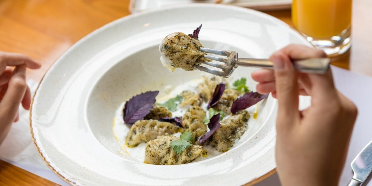 Tasty meat meal, a woman eating with a fork