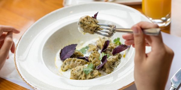 Tasty meat meal, a woman eating with a fork